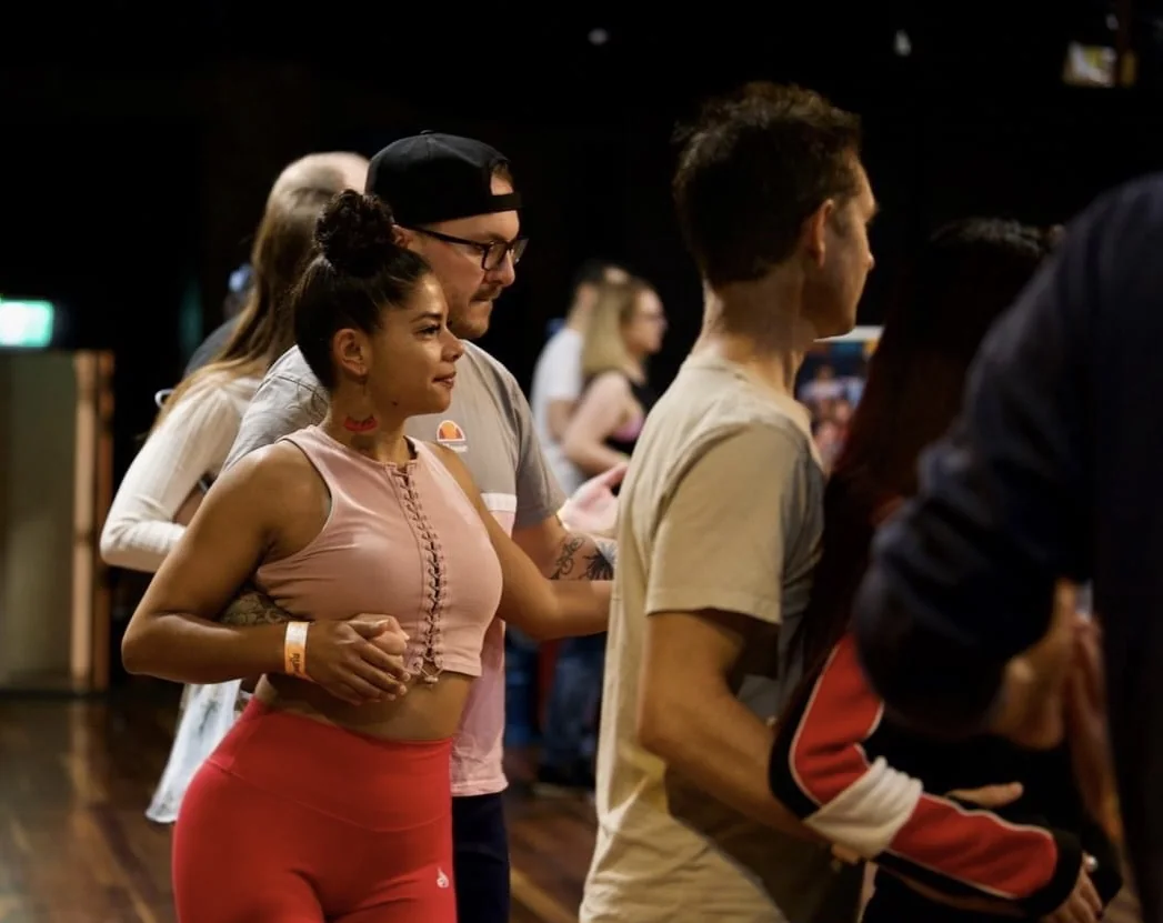 Students rotating partners during a social Latin dance class